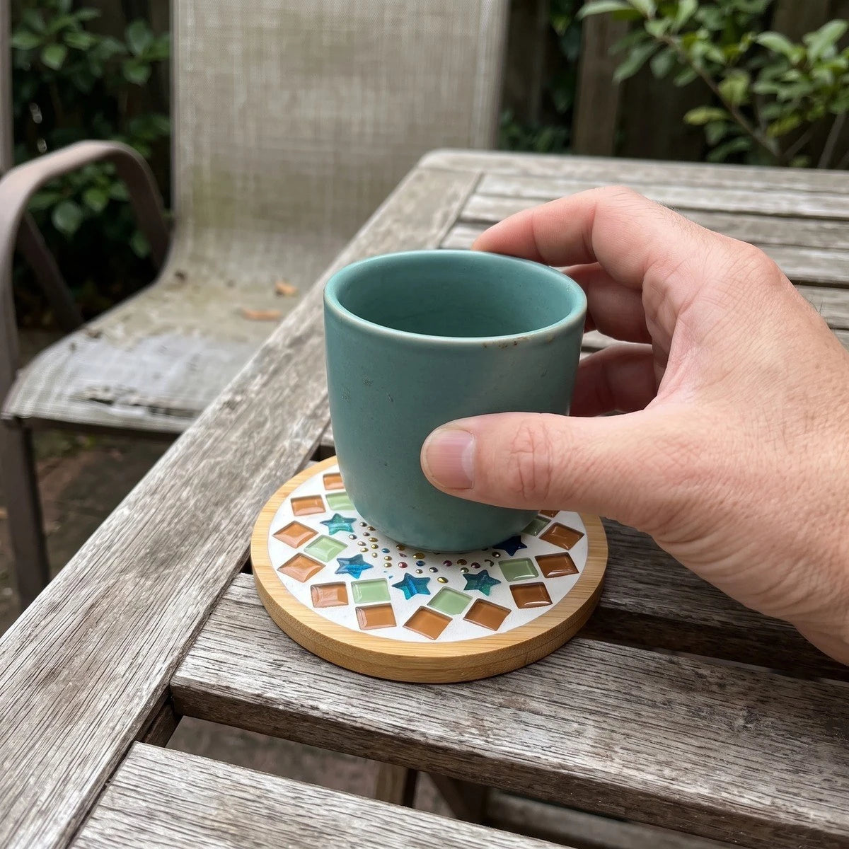 Adult maker with a mosaic coaster on a covered porch