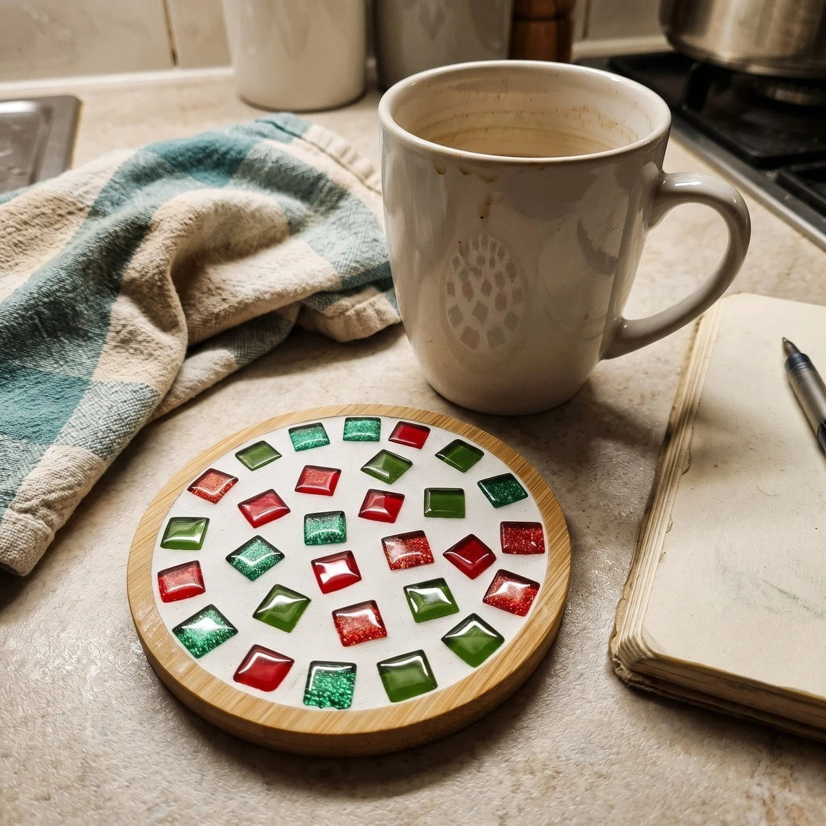 Glass mosaic coaster beside a notebook and laptop